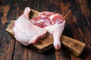 Uncooked Raw duck legs, Poultry meat on a wooden board. Wooden background. Top view