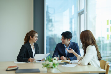 Group of asian business meeting and discussing with new startup idea project. Creative business people planning strategy analysis and brainstorm with document report in office.