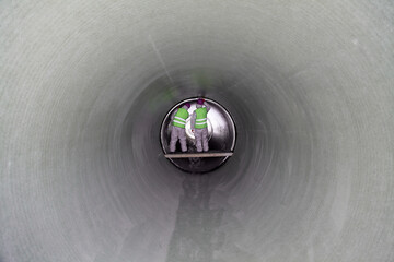 Man in a big pipe 2. Human inside a large shiny metal pipe