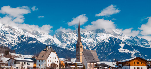 Winter landscape with a church and the famous Hochkoenig summit in the background at Maria Alm,...