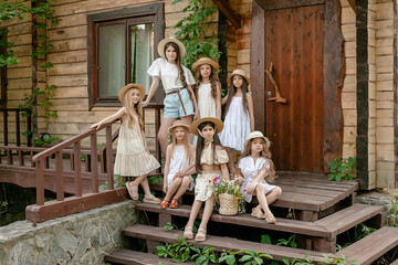 Preteen girls posing together on doorstep of rural cottage on summer day