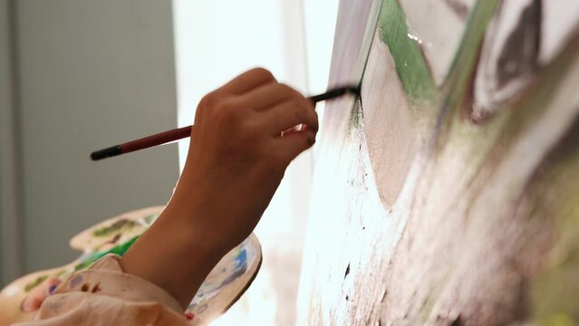 Art studio - woman artist drawing painting on canvas