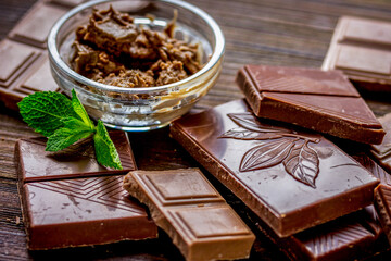 black and milk chocolate bars with mint dark wooden table background