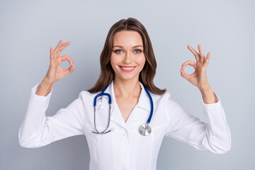 Photo of positive charming lady two hands fingers make okey symbol approve feedback isolated on...