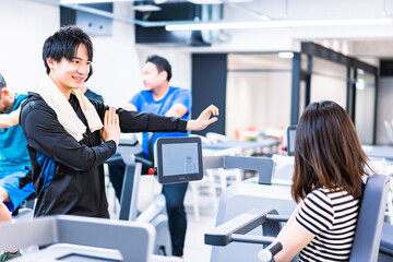 ジムでトレーナーの指導を受ける若い女性