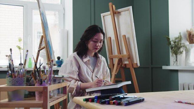 A woman artist sketches in an art studio