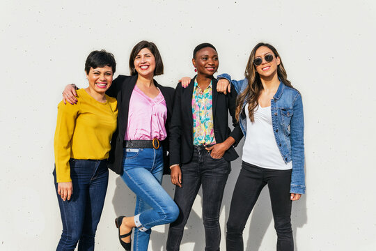 Group of positive diverse women on street