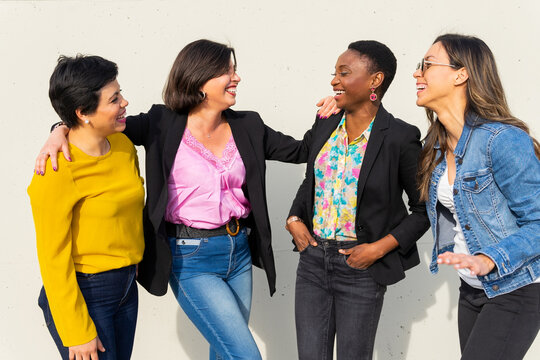 Group of positive diverse women on street