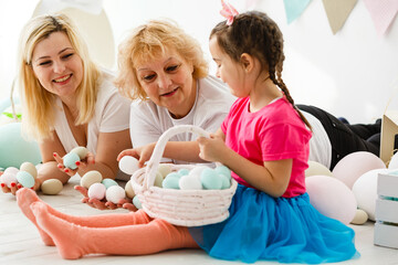 Obraz na płótnie Canvas Easter concept. Happy llittle girl and grandmother with Easter eggs