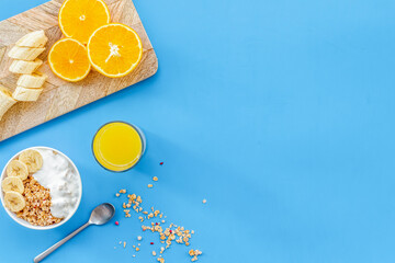 Naklejka premium food for healthy breakfast with granola and fresh orange juice on bright blue background top view mock up