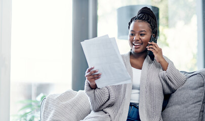 Great financial advice is just a call away. Shot of a young woman going over paperwork and using a smartphone on the sofa at home.