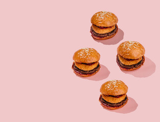 Creative burger pattern with beef patty, camembert and cherry on a pink background. minimal style