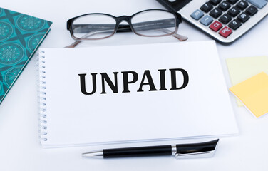 Text, word Unpaid on a notepad on an office desk, a business concept