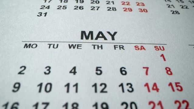 May 2022. Calendar. Save the date. Macro detailed calendar with holidays, weekend and working days. Second world war win date. Many holidays. Spring month. Map 9th. Rotating calendar. Close up shot.
