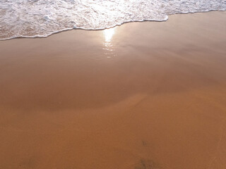 Soft white ocean wave on a clean sandy beach