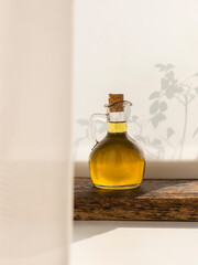 olive oil in glass bottle on wooden board and white background.