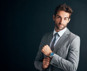 Dress like you mean business. Studio shot of a confident and stylishly dressed young businessman against a black background.