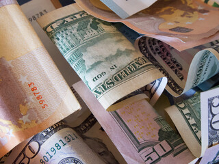 Cash banknotes dollars and euros are mixed up, a close-up shot.