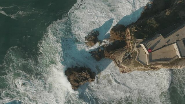 Topdown drone footage from Nazare lighthouse, Portugal , slowed down 4 times, giant wave town - Vista de drone com camera picada sobre o farol da Nazaré, Portugal, em camera lenta 4 vezes