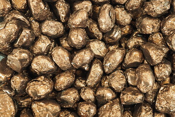 Chocolate sweets. Sweets in golden foil. Full frame background.