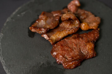 grilled beef on plate over black background studio