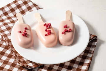 Cheesecake on a stick. Cake in the form of ice cream. White table.