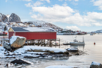Rorbuer fishing house with boat on coastline on winter season in Lofoten islands