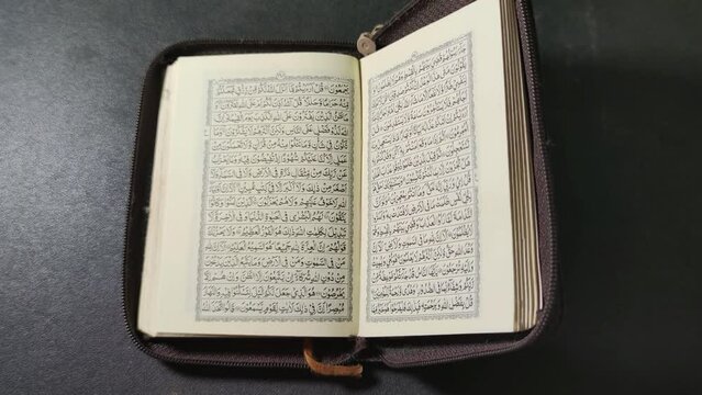Probolinggo East Java Indonesia, 21 March 2022 - Pocket Quran Islam holy book of Muslims isolated on black background