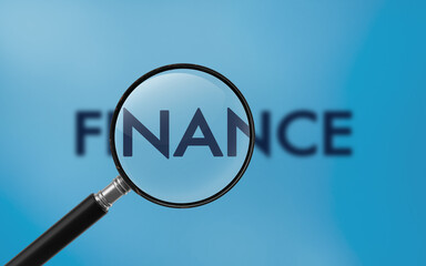 Finance Text On A Magnifier Against Blue Background