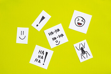 joke concept sketched on pieces of paper. Ha ha text and drawn spider, laughing emoji on green background. April Fool's Day.  April 1 - obrazy, fototapety, plakaty