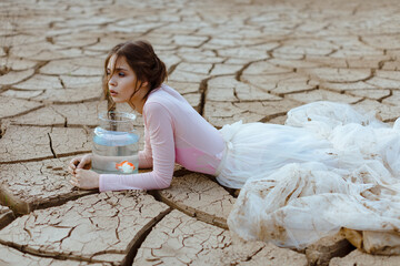 Climate change and global warming concept girl with water saves fish 