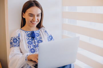 Young ukrainian woman wearing vyshyvanka working from home