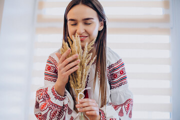Young ukrainian woman in vyshyvanka with wheat spike