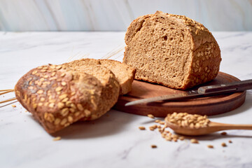 A loaf of sourdough rye bread on a rustic wooden board.