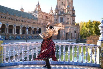 Obraz premium Young and beautiful typical Spanish woman dancing flamenco with urban and modern clothes, wearing her hair loose and long. Concept of flamenco cultural heritage of humanity.