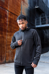 Handsome young African American man with dreadlocks in an urban setting