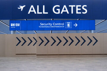 View of an airport signpost directing travellers to the security check and departure gates.