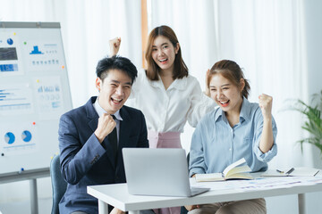 happy smiling asian young business poeple in formal wear, they showing success symbol meaning of project successful and completed with happy smiling face and urban view background