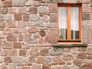 Fototapeta na wymiar A window isolated on rough stonewall, space for your text or logo