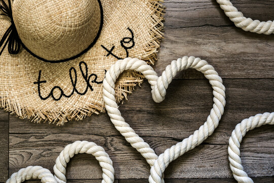 Inscription love and symbol heart made of rope on a wooden background