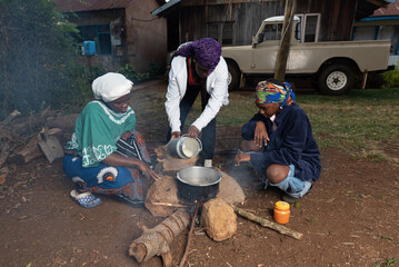 Young African teenager pouring fresh milk into pot 
