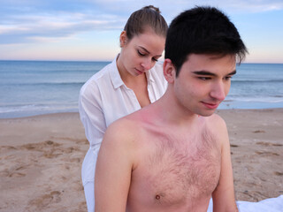 Male patient and therapist during an outdoors massage session on a beach in Valencia.