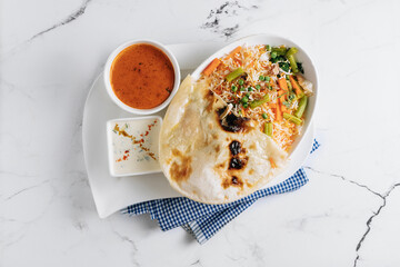 vegetable biryani with raita and sauce in a dish isolated on napkin side view on grey background famous indian and pakistani food