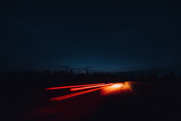 The trail of the car lights with long exposure in the field in the night