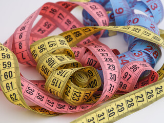 A pile of colorful measuring tapes. Close up.