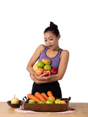 Pretty Asian woman wearing sportwear, holding varieties of fresh fruits with both hands