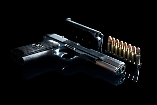 View of the muzzle of the pistol. Old russian semiautomatic pistol (Tokarev) with ammunition on black mirror base. 