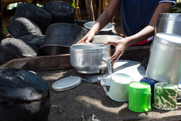 Young Teenage African Girl washing dishes at and outdoor area