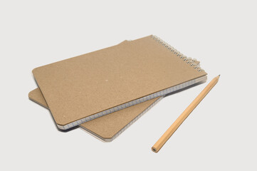 Notepad with a simple pencil on a gray background. Minimalistic layout for design.