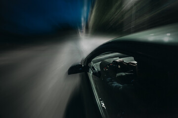 View from Side of Car moving in a night city, Blured road with lights with man in car on high speed. Blured way of car